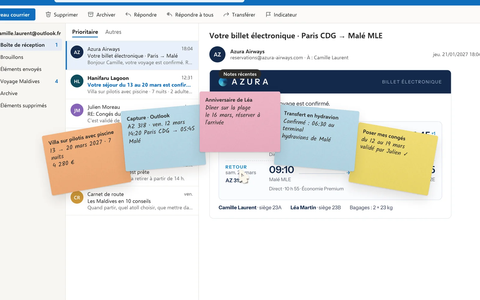 Les notes du voyage ouvertes en éventail autour du pointeur, au-dessus d’Outlook